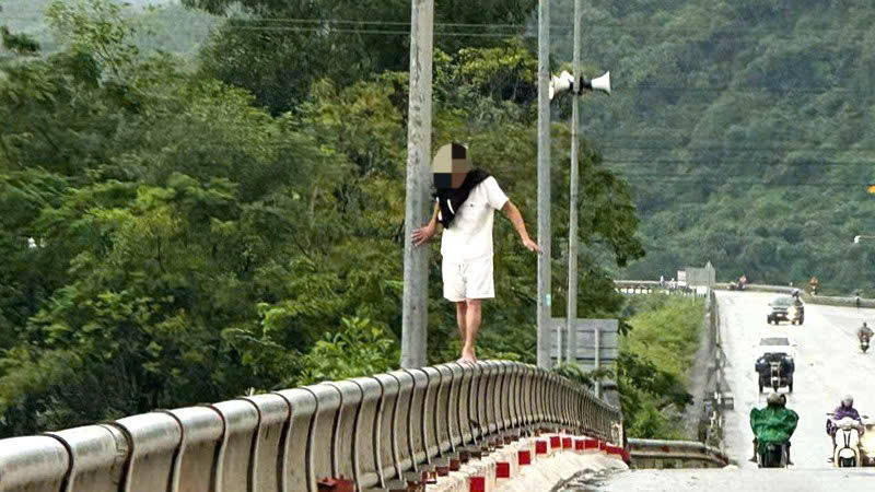 Nam thanh niên ‘làm xiếc’ trên lan can cầu lúc mưa lũ缩略图